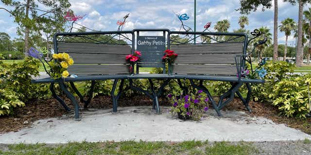 Gabby Petito memorial bench in Florida with flowers.