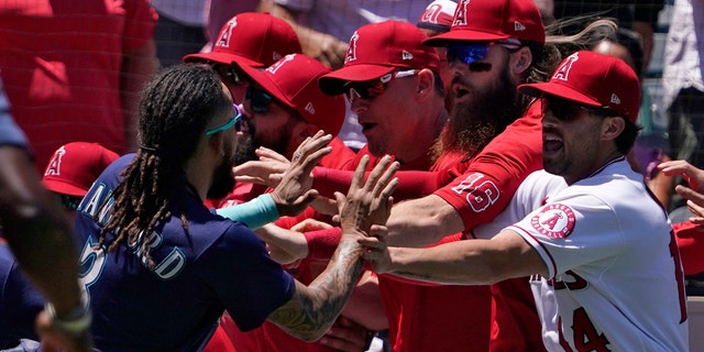 Seattle Mariners' J.P. Crawford, left, and several members of the Los Angeles Angels scuffle after Mariners' Jesse Winker was hit by a pitch during the second inning of a baseball game Sunday, June 26, 2022, in Anaheim, Calif. 