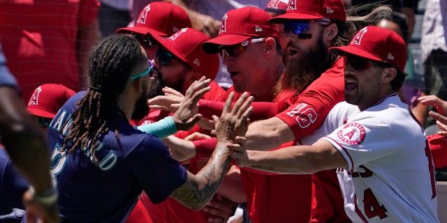 Seattle Mariners' J.P. Crawford, left, and several members of the Los Angeles Angels scuffle after Mariners' Jesse Winker was hit by a pitch during the second inning of a baseball game Sunday, June 26, 2022, in Anaheim, Calif. 