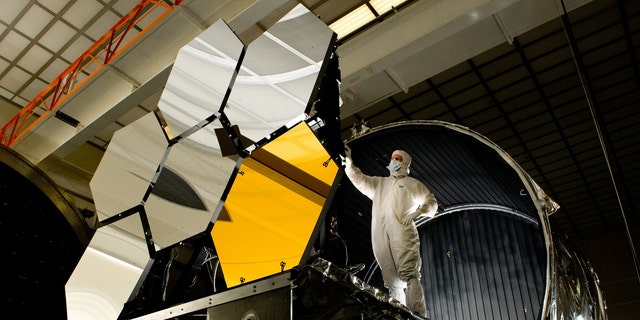 Ball Aerospace 的首席光学测试工程师 Dave Chaney 在进行 X 射线冷却和测试之前检查了六个主镜部分，这是 NASA 詹姆斯韦伯太空望远镜的关键元件。 位于阿拉巴马州亨茨维尔的美国宇航局马歇尔太空飞行中心的制冷设施。