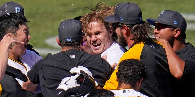 Jack Suwinsky, center, of the Pittsburgh Pirates is swarmed by teammates after hitting a walk-off solo home run from San Francisco Giants relief pitcher Tyler Rogers during the ninth inning of a baseball game in Pittsburgh, Sunday, June 19, 2022.  It was Suwinsky's third solo home run of the game.
