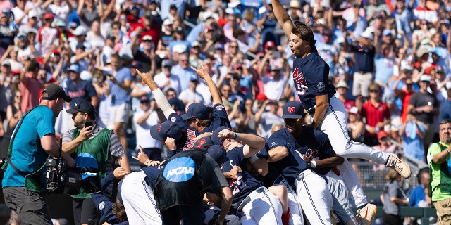 Mississippi's Jack Washburn, right, leaps on top of the team pile in celebration of their 4-2 victory over Oklahoma in Game 2 of the NCAA College World Series baseball finals, Sunday, June 26, 2022, in Omaha, Neb. Mississippi defeated Oklahoma 4-2 to win the championship.