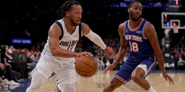 Jalen Brunson #13 of the Dallas Mavericks drives around Alec Burks #18 of the New York Knicks in the first half at Madison Square Garden on January 12, 2022 在纽约市.