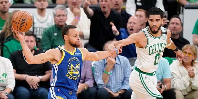 Golden State Warriors guard Stephen Curry looks to pass against Celtics forward Jayson Tatum during the NBA Finals, Thursday, June 16, 2022, in Boston.