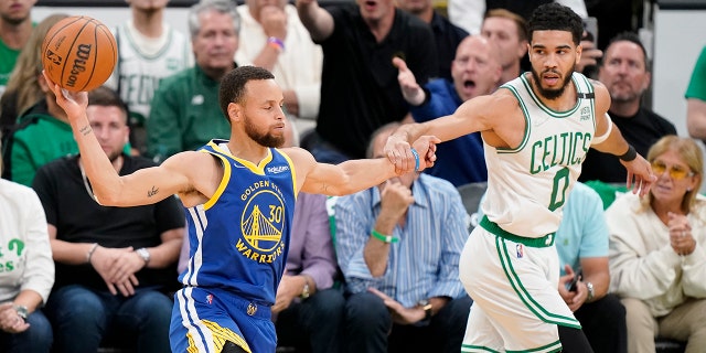 Golden State Warriors guard Stephen Curry looks to pass against Celtics forward Jayson Tatum during the NBA Finals, Thursday, June 16, 2022, in Boston.