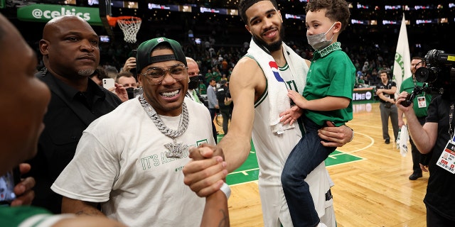 Jayson Tatum of the Boston Celtics celebrates with son Deuce and singer Nelly after the 116-100 win against the Golden State Warriors on June 8, 2022, in Boston.