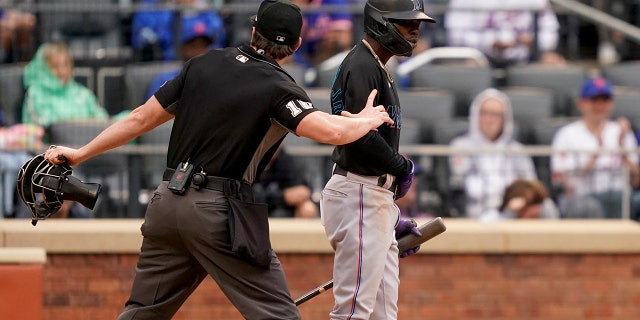 Umpire Adam Beck kicks Jazz Chisholm Jr. of the Miami Marlins out of play after arguing and striking balls against the New York Mets in the ninth inning of a baseball game against the New York Mets on Saturday, June 18, 2022. 