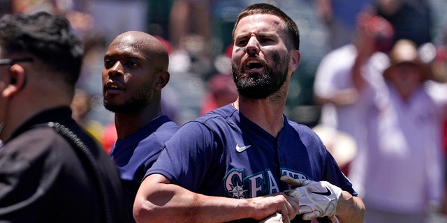 Seattle Mariners' Jesse Winker, right, and Justin Upton jaw with fans after a brawl between members of the Mariners and the Los Angeles Angels during the second inning of a baseball game Sunday, June 26, 2022, in Anaheim, Calif. The fight started after Winker was hit by a pitch.