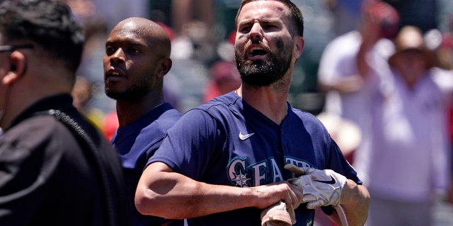 Seattle Mariners' Jesse Winker, right, and Justin Upton jaw with fans after a brawl between members of the Mariners and the Los Angeles Angels during the second inning of a baseball game Sunday, June 26, 2022, in Anaheim, Calif. The fight started after Winker was hit by a pitch.