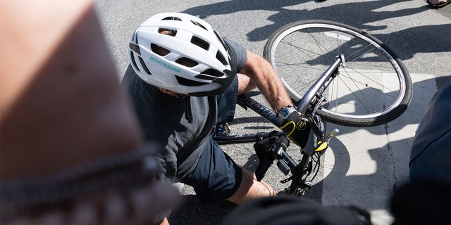 President Biden falls from his bicycle as he approaches well-wishers after a bike ride at Gordon Pond State Park in Rehoboth Beach, Delaware, on June 18, 2022.