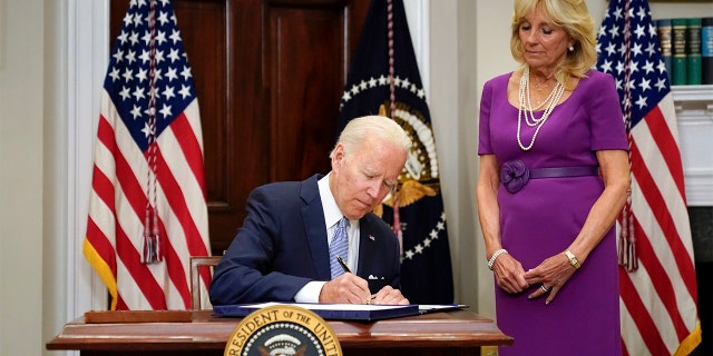 President Biden signs into law S. 2938, the Bipartisan Safer Communities Act gun safety bill, in the Roosevelt Room of the White House in Washington, Saturday, June 25, 2022. First lady Jill Biden looks on at right. 