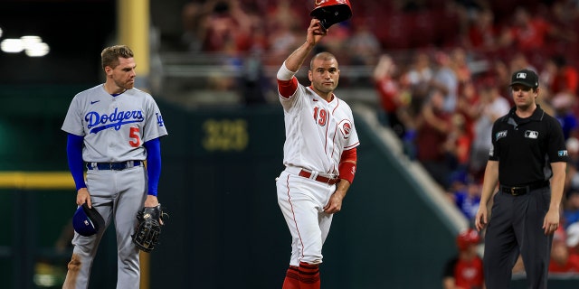 Cincinnati Reds' Joey Votto, right, acknowledges the fans after hitting a single, as Freddie Freeman watches during the ninth inning of a baseball game in Cincinnati, Tuesday, June 21, 2022. Votto's single was his 1,000th hit at Great American Ballpark. The Dodgers won 8-2. 