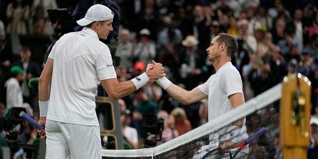 John Isner of the US shakes hands with Britain's Andy Murray after defeating him in their singles tennis match on day three of the Wimbledon tennis championships in London, Wednesday, June 29, 2022.