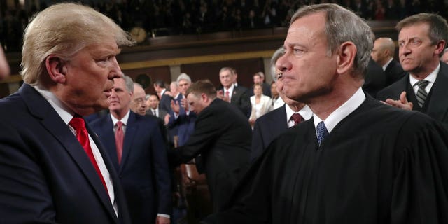 Donald Trump shakes hands with Supreme Court Chief Justice John Roberts