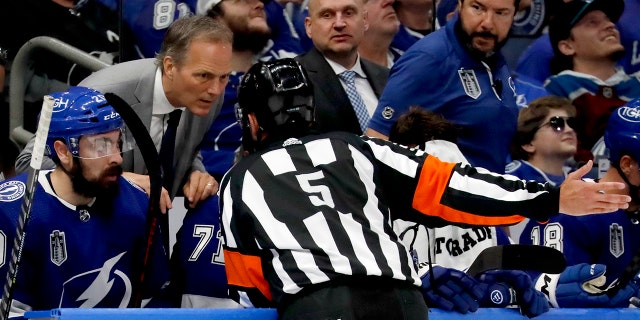 Head coach Jon Cooper of the Tampa Bay Lightning speaks to referee Chris Rooney, #5, during the second period Game Three of the 2022 NHL Stanley Cup Final at Amalie Arena on June 22, 2022 in Tampa, Florida.