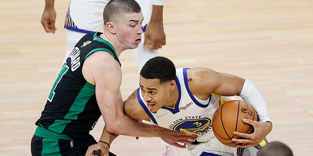 Golden State Warriors guard Jordan Poole, right, is defended by Boston Celtics guard Payton Pritchard during the first half of Game 5 of basketball's NBA Finals in San Francisco, Monday, June 13, 2022.