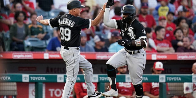Chicago White Sox's Josh Harrison, right, celebrates his two-run home run against the Los Angeles Angels with third base coach Joe McEwing during the fifth inning of a baseball game Tuesday, June 28, 2022, in Anaheim, Calif.