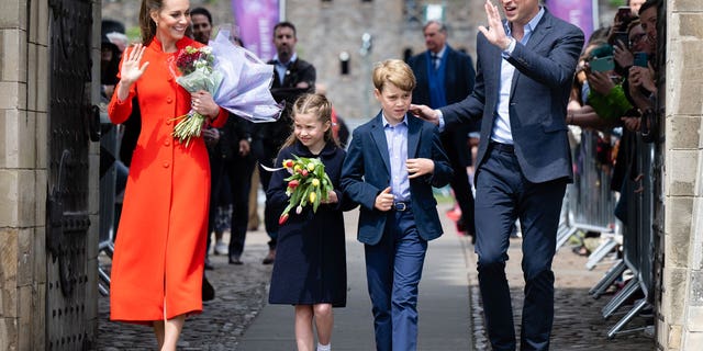 Catherine, Duchess of Cambridge, Princess Charlotte of Cambridge Prince William, Duke of Cambridge and Prince George of Cambridge wave at onlookers during a visit to Cardiff Castle on June 4.