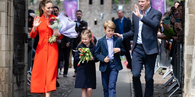 Catherine, Duchess of Cambridge, Princess Charlotte of Cambridge Prince William, Duke of Cambridge and Prince George of Cambridge wave at onlookers during a visit to Cardiff Castle on June 4.