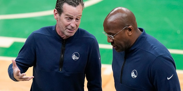 Golden State Warriors assistant coach Kenny Atkinson, left, talks with assistant coach Mike Brown during a timeout during the first quarter of Game 4 of basketball's NBA Finals against the Boston Celtics, Friday, June 10, 2022, in Boston.