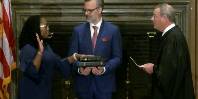 Judge Ketanji Brown Jackson is sworn in as an associate justice of the Supreme Court by Chief Justice John Roberts as Jackson’s husband Patrick Jackson holds the Bible in Washington, June 30, 2022.