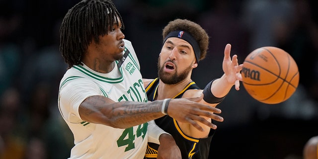 Boston Celtics center Robert Williams III passes the ball against Golden State Warriors guard Klay Thompson on Friday, June 10, 2022 in Boston.