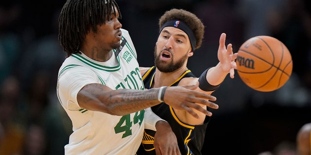 Boston Celtics center Robert Williams III passes the ball against Golden State Warriors guard Klay Thompson on Friday, June 10, 2022 in Boston.