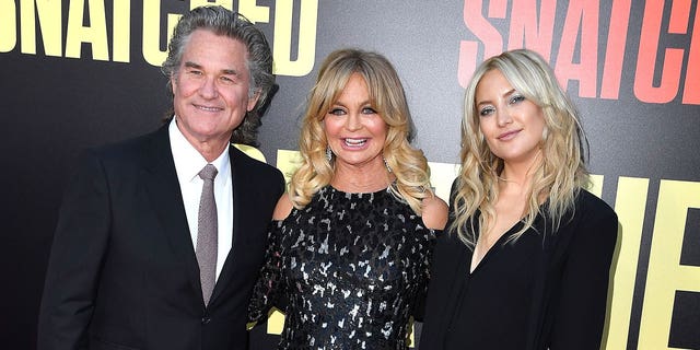 Kate Hudson with her mother, Goldie Hawn, and Goldie's partner, Kurt Russell. Although Kurt is not Kate's biological father, she shared that she considers him her dad.