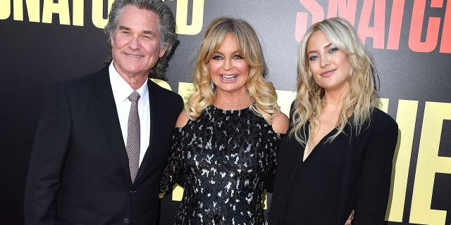 Kate Hudson with her mother, Goldie Hawn, and Goldie's partner, Kurt Russell. Although Kurt is not Kate's biological father, she shared that she considers him her dad.