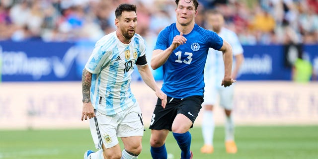 Lionel Messi of Argentina duels for the ball with Soomets Markus of Estonia during the international friendly match between Argentina and Estonia at Estadio El Sadar on June 05, 2022 in Pamplona, Spain.