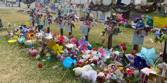 Crosses with flowers are dedicated to each of the victims of the Uvalde school shooting. People have brought flowers, stuffed animals and cards to the town square memorial one month later. 