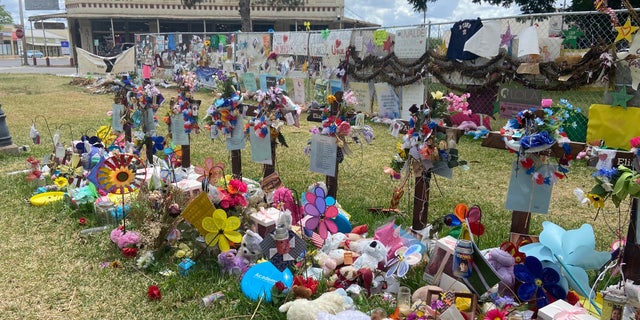 Crosses with flowers are dedicated to each of the victims of the Uvalde mass shooting. People bring flowers, stuffed animals and cards to the town square memorial one month later. 