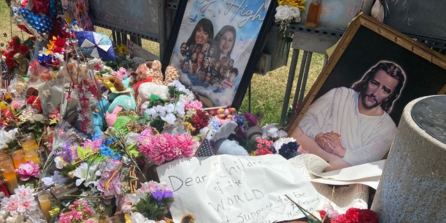 Visitors from McAllen, Texas, left a sign at the town square memorial in Uvalde. It says, "Dear children of the world, it's not supposed to be this way." 