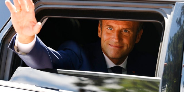 France's President Emmanuel Macron waves as he leaves a polling station after voting in the first round of a French parliamentary election in Le Touquet, northern France, June 12, 2022.