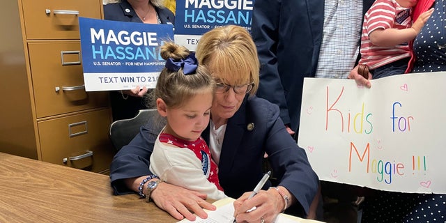 Democratic Sen. Maggie Hassan of New Hampshire, with the daughter of a friend sitting in her lap, formally files for reelection, on June 10, 2022 in Concord, N.H.