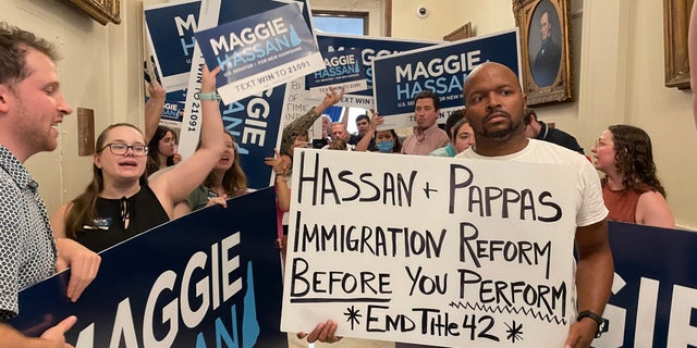 Immigration activists protesting Sen. Maggie Hassan's border security stance are outnumbered by Hassan supporters as the Democratic senator from New Hampshire arrives at the State House to file for re-election, 在六月 10, 2022 in Concord, N·H.