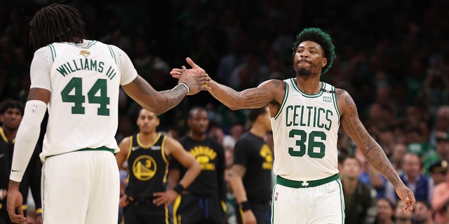 Marcus Smart and Robert Williams III of the Celtics react to a play against the Golden State Warriors during the NBA Finals at TD Garden on June 8, 2022, in Boston.