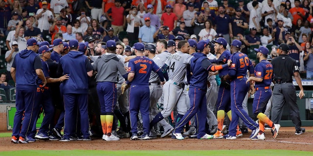 Both dugouts empty and umpires try to keep order after Seattle Mariners batter Ty France was hit by a pitch from Houston Astros relief pitcher Hector Neris during the ninth inning of a baseball game Monday, June 6, 2022, in Houston.