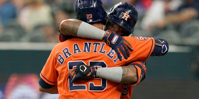 Houston Astros' Martin Maldonado, right hugs teammate Michael Brantley (23) after Maldonado hit a solo home run during the fourth inning of a baseball game against the Texas Rangers in Arlington, Texas, Wednesday, June 15, 2022. 