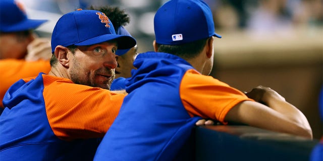 Pitchers Max Scherzer #21 and Jacob deGrom #40 of the New York Mets talk in the dugout during a game against the Milwaukee Brewers at Citi Field on June 14, 2022 in New York City. The Mets defeated the Brewers 4-0. 