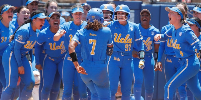 UCLA's Maya Brady (7) is met by her team at home plate after a home run during the seventh inning of an NCAA softball Women's College World Series game against Oklahoma on Monday, June 6, 2022, in Oklahoma City. UCLA won 7-3.