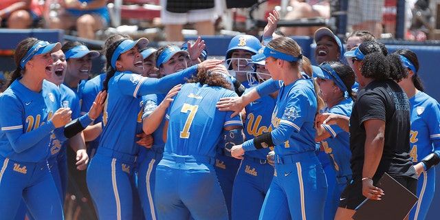 UCLA's Maya Brady (7) celebrates with her team at home plate following a home run during the seventh inning of an NCAA softball Women's College World Series game against Oklahoma on Monday, June 6, 2022, in Oklahoma City. UCLA won 7-3.
