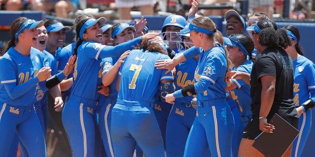 UCLA's Maya Brady (7) celebrates with her team at home plate following a home run during the seventh inning of an NCAA softball Women's College World Series game against Oklahoma on Monday, June 6, 2022, in Oklahoma City. UCLA won 7-3.