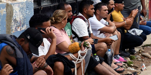 Migrants wait to collect payments sent by their relatives to continue with the caravan heading to the border of Mexico and the United States, in Huixtla, State of Chiapas, Mexico on June 10, 2022. 