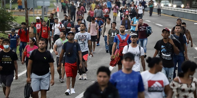 2022 m. birželio 9 d. migrantai vaikšto keliu prie migrantų karavano Huikstloje, Čiapaso valstijoje, Meksikoje. Karavanas iš Huikstlos į Mapastepeką vėl startavo su maždaug 3 000 migrantų. 