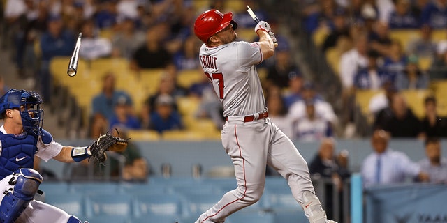 Mike Trout #27 of the Los Angeles Angels breaks his bat as he hits a single against the Los Angeles Dodgers during the ninth inning at Dodger Stadium.