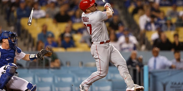 Mike Trout #27 of the Los Angeles Angels breaks his bat as he hits a single against the Los Angeles Dodgers during the ninth inning at Dodger Stadium.