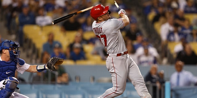 Mike Trout #27 of the Los Angeles Angels breaks his bat as he hits a single against the Los Angeles Dodgers during the ninth inning at Dodger Stadium on June 14, 2022 in Los Angeles, California. The broken bat hit home plate umpire Nate Tomlinson #114.