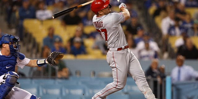 Mike Trout #27 of the Los Angeles Angels breaks his bat as he hits a single against the Los Angeles Dodgers during the ninth inning at Dodger Stadium on June 14, 2022 in Los Angeles, California. The broken bat hit home plate umpire Nate Tomlinson #114.