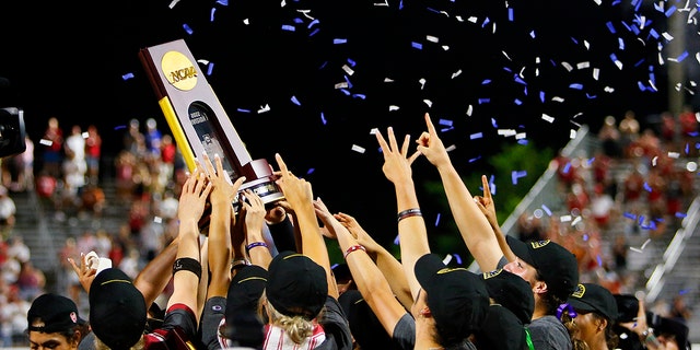 The Oklahoma Sooners celebrate by hoisting the NCAA trophy after defeating the Texas Longhorns during the NCAA Women's College World Series championship finals at the USA Softball Hall of Fame Complex on June 9, 2022 in Oklahoma City, Oklahoma.  Oklahoma won 10-5. 